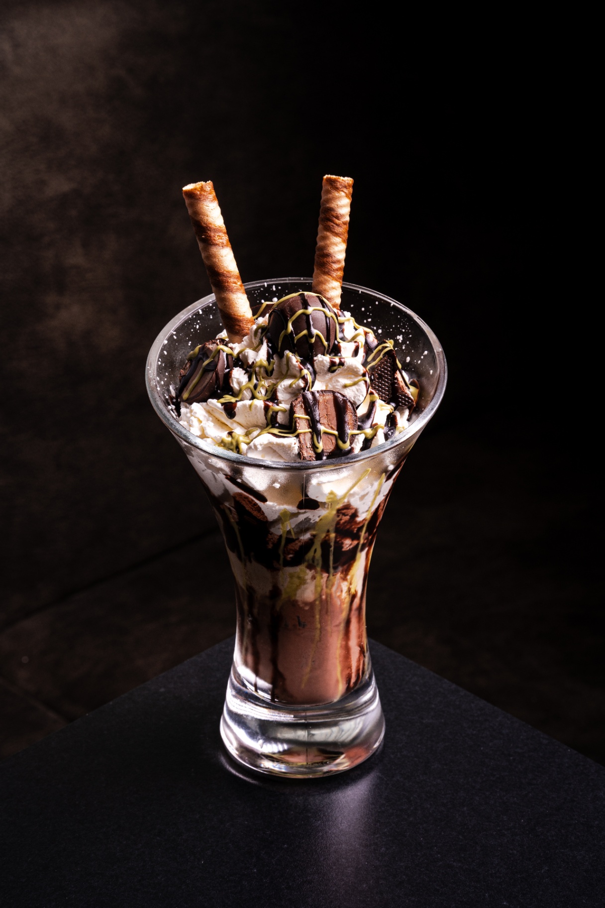 Schokoladen-Eisbecher mit Sahne und Pralinen